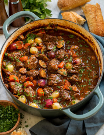 Beef bourguignon in a blue wide braiser pot.