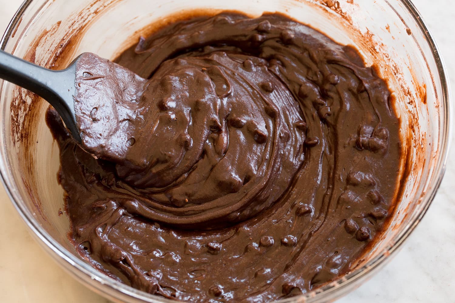 Completed homemade brownie bite batter in a glass mixing bowl.