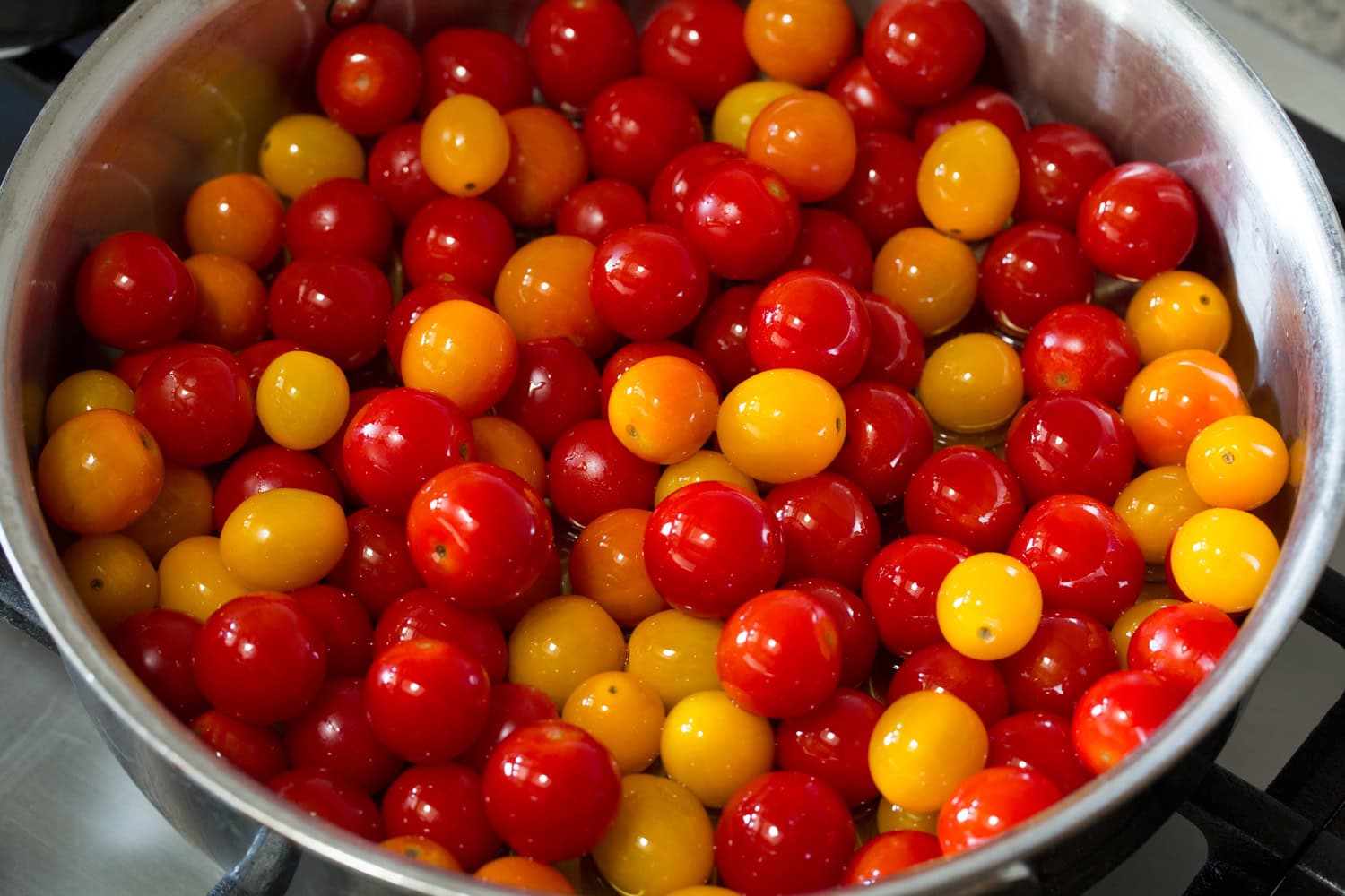 Cherry tomatoes and olive oil in a saute pan.