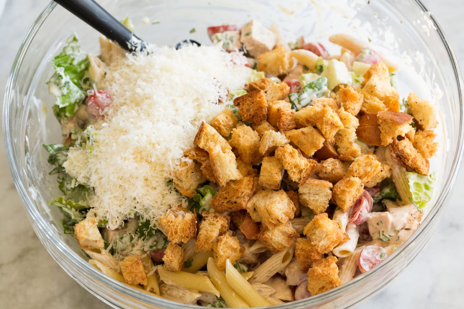 Croutons and parmesan added to caesar pasta salad.