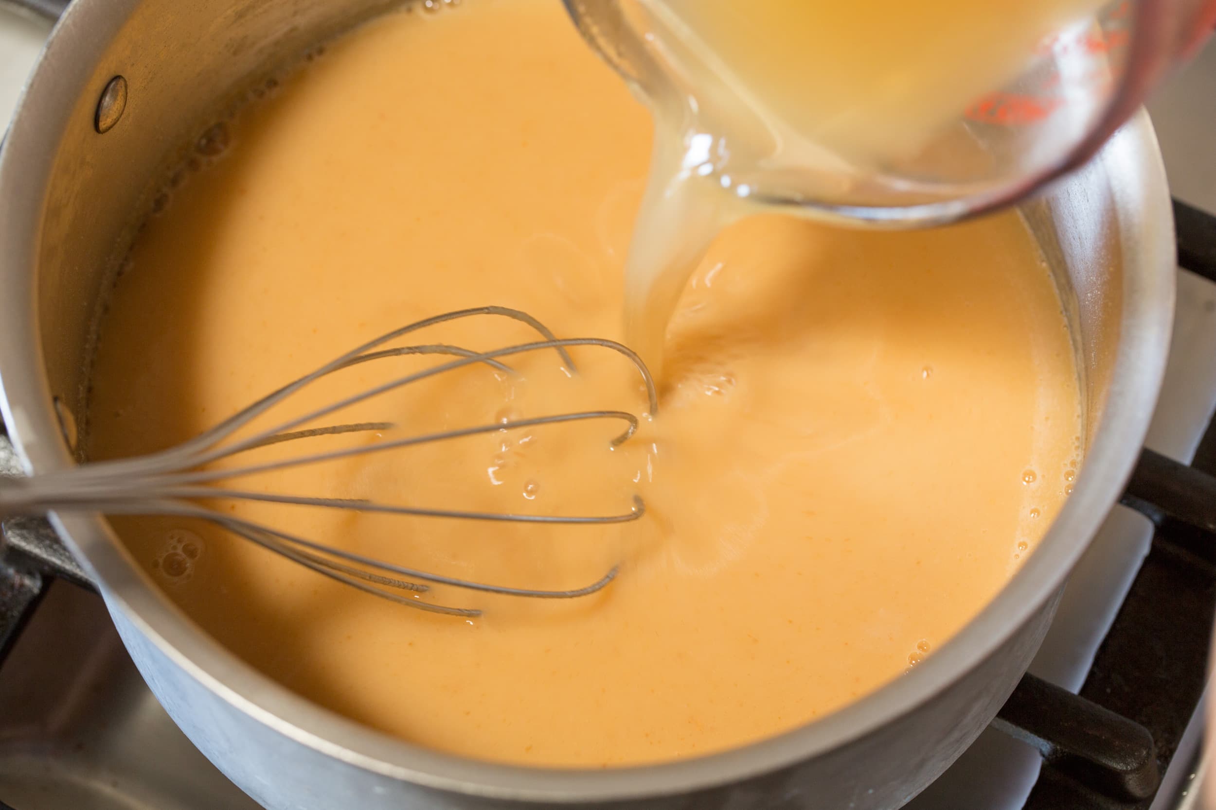 Broth added to roux in pan.