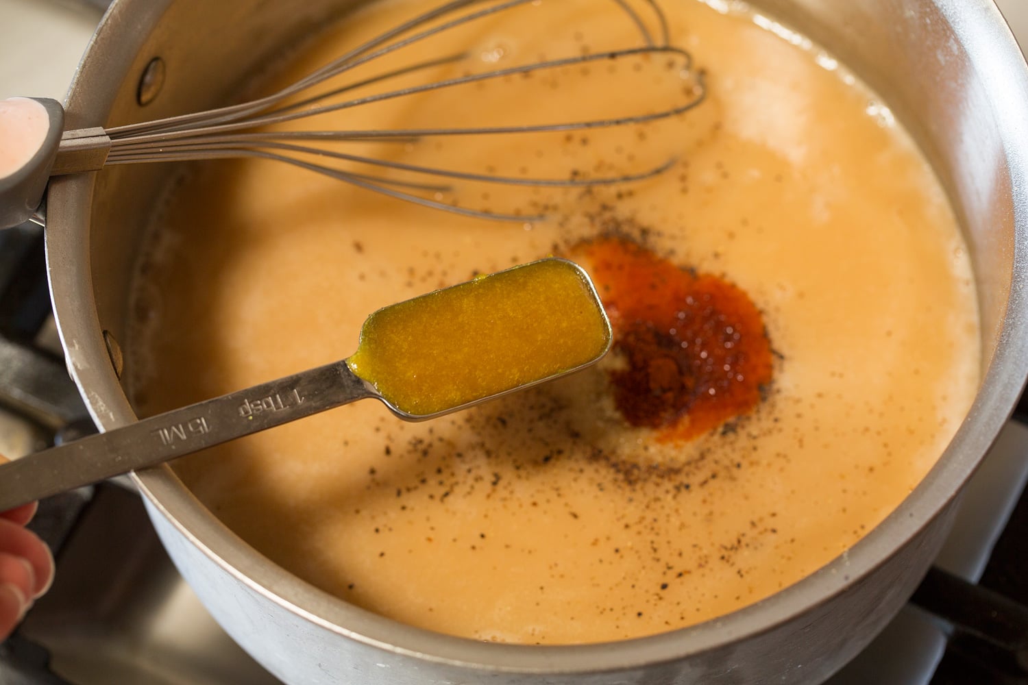 Adding chicken base and seasonings to gravy.