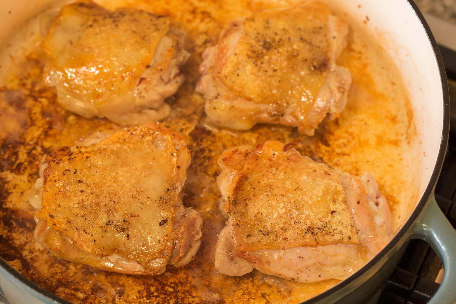 Chicken thighs browned in a pot.