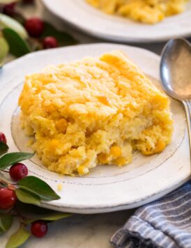 Single serving of corn casserole shown on a white plate with a spoon to the side.