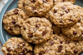 Cowboy cookies stacked on a blue serving plate.