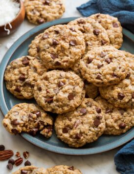 Cowboy cookies stacked on a blue serving plate.