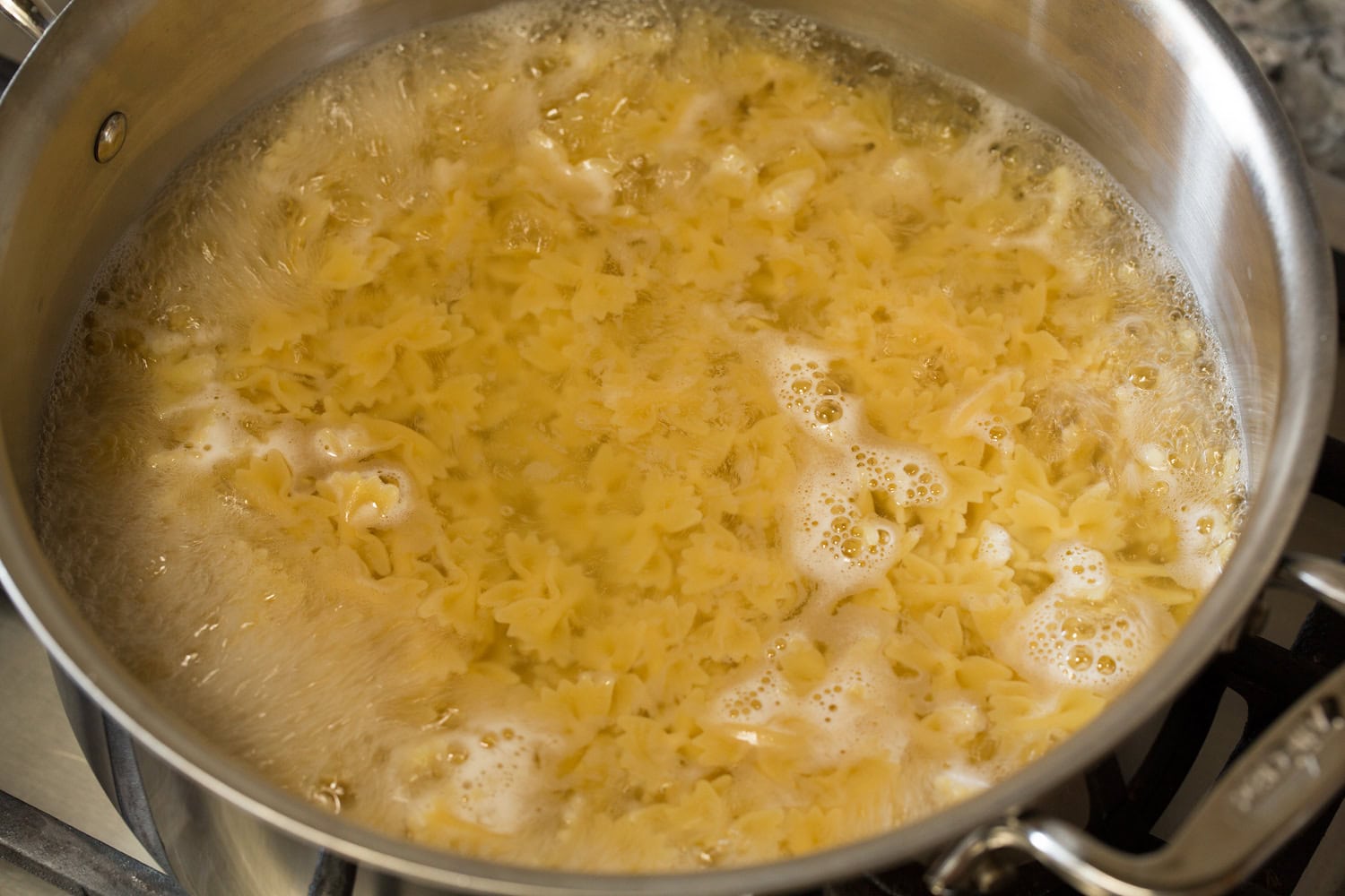 Farfalle pasta cooking in a large pot of water.