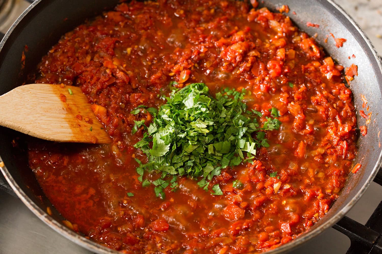 Cilantro added to salsa ranchera mixture.