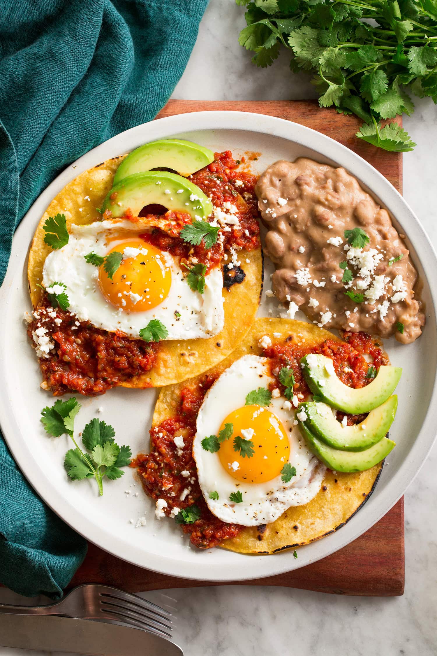 Huevos rancheros shown with a serving suggestion of side of refried beans.