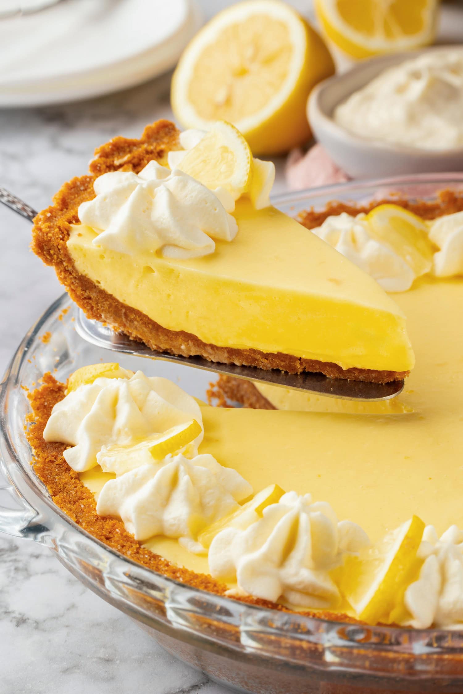 Cut slice of lemon icebox pie being lifted from pie dish.