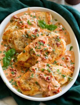 Marry me chicken on a platter. Pan seared chicken breasts are coated with a sun dried tomato basil sauce.