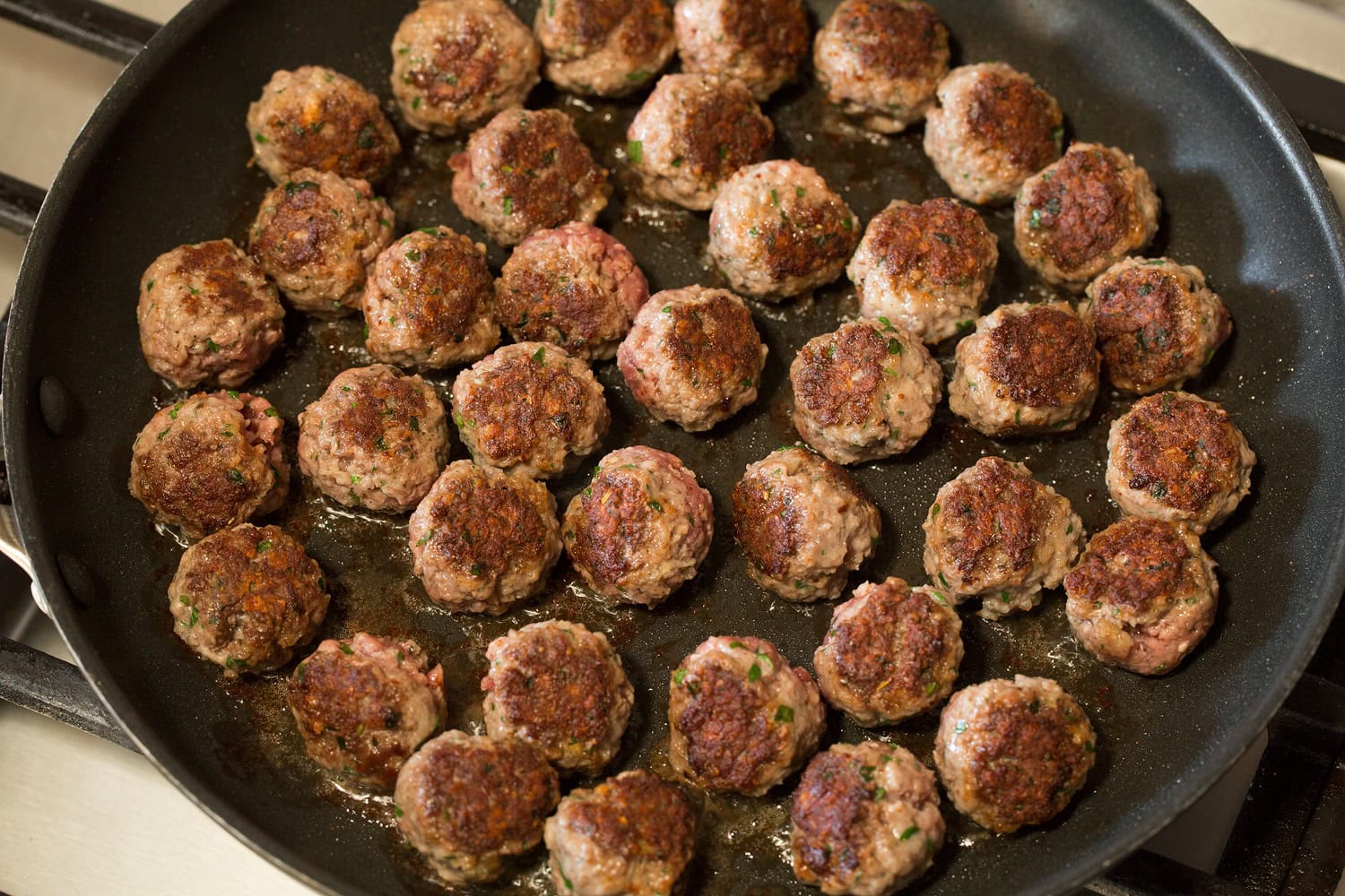 Meatballs in skillet after being browned.