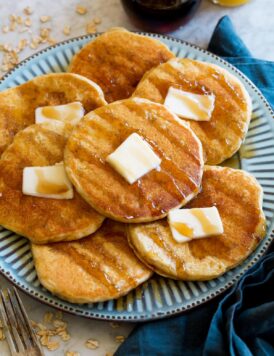 Pancakes shown at a side angle on a large blue plate.