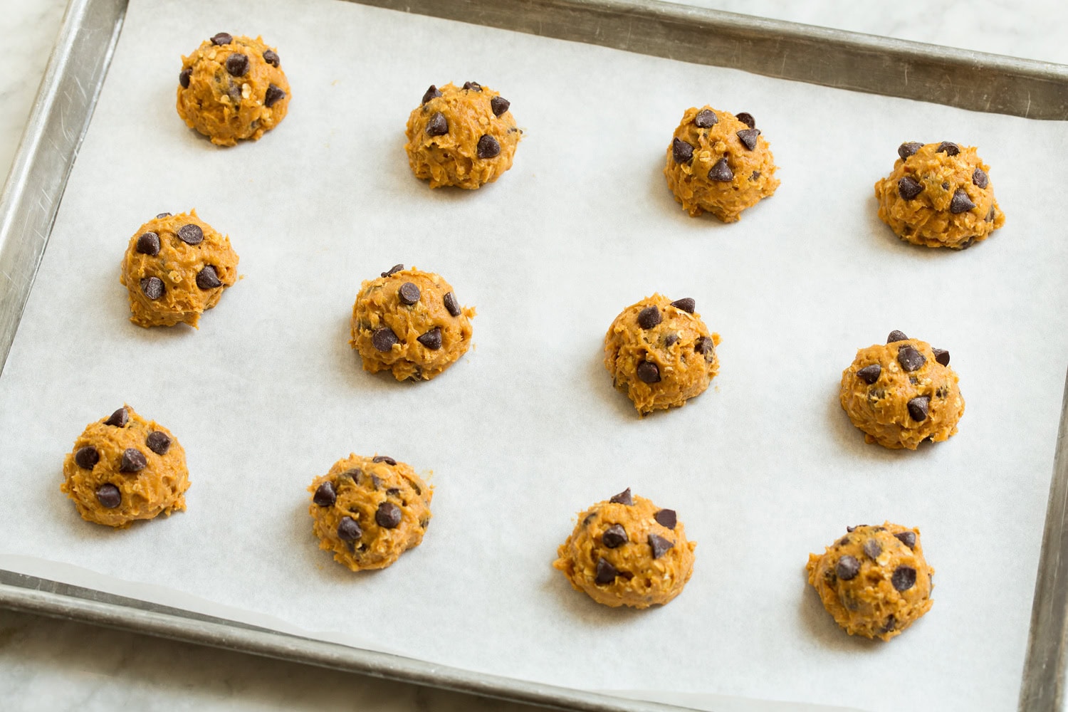 Cookie dough balls on a baking sheet.