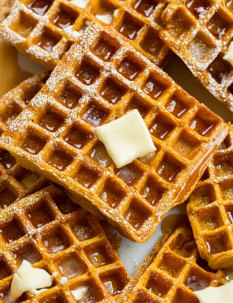 Close up photo of pumpkin waffle with syrup and butter.