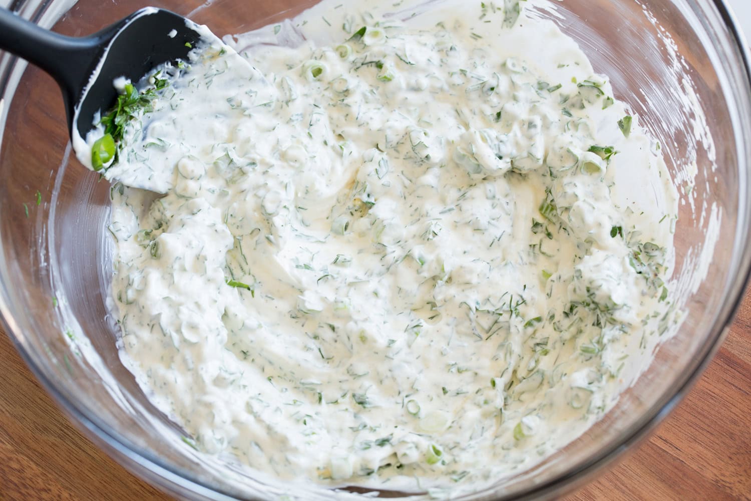 Mixed dressing for potato salad in a mixing bowl.