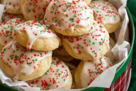 Ricotta cookies stacked in a Christmas tin.