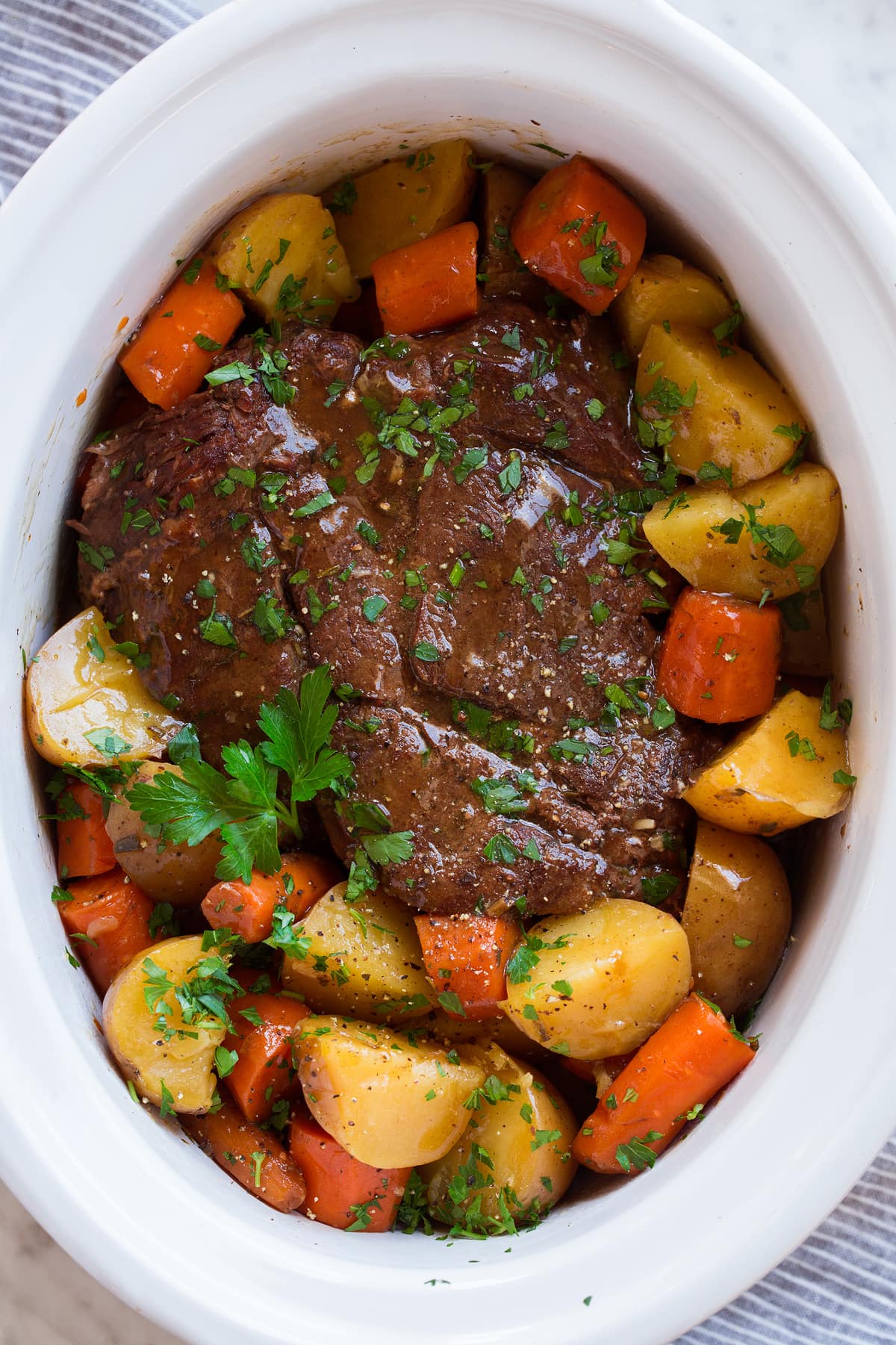 Slow cooker pot roast in a white crockpot