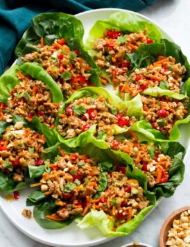 Thai chicken lettuce shown assembled close together on a white oval platter.